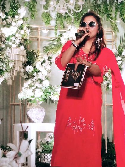 On stage, mic in hand, ready to set the event on fire with my energy. The red outfit adds to the powerful vibe.