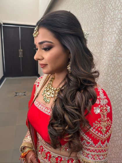 A side view of the bridal half-up style with voluminous curls, a perfect choice for a wedding ceremony.