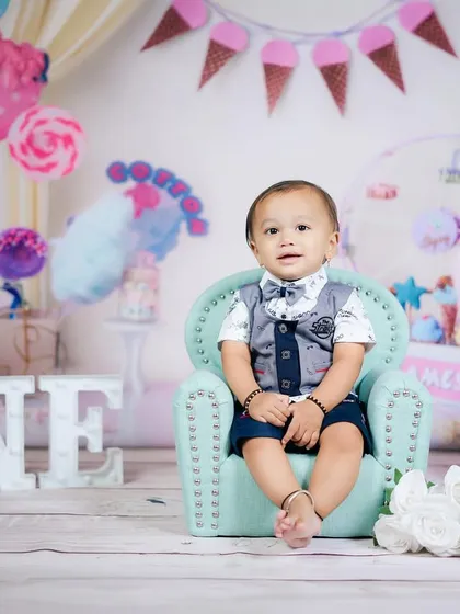 A charming first birthday setup with an ice cream parlor theme. This little gentleman looks perfectly poised in his mini armchair.