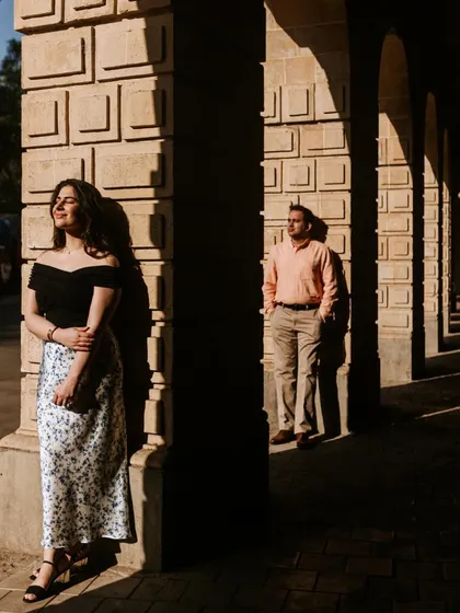 A beautiful portrait using the golden hour light. The play of light and shadow across the columns creates a visually interesting and romantic setting.