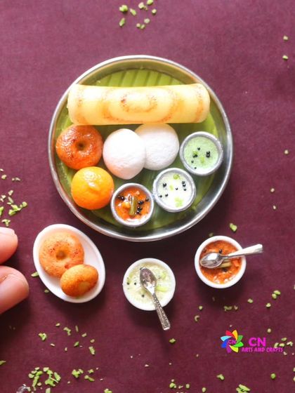 A close-up of a South Indian breakfast platter, showing the detail on the idli, vada, and dosa.