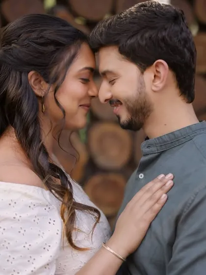 A sweet and simple moment between the couple. The natural, earthy tones of their outfits and the wooden backdrop create a warm and inviting feel for this pre-wedding portrait.