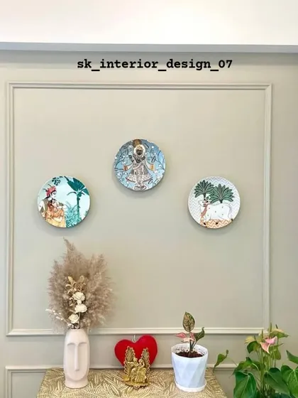 A close-up of the decorative wall arrangement in the entryway. The traditional-style plates are mounted within a classic wall moulding, blending cultural motifs with contemporary design.