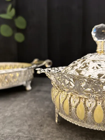 A bowl that does more than serve, it stuns. Intricately engraved, delicately enameled, and finished with a crystal finial, this lidded piece is made to be the center of every conversation.
