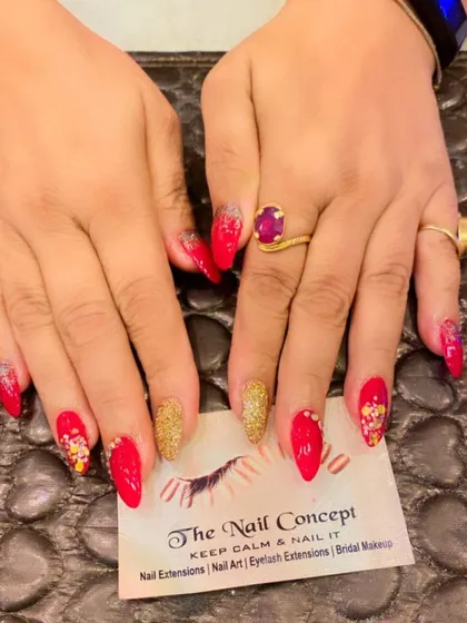 A luxurious red and gold set perfect for any festive celebration. The almond-shaped nails feature a mix of red polish, gold glitter, and abstract art with gold foil.