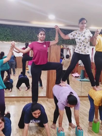 A fantastic group acro yoga pose. This human pyramid is a testament to the trust, strength, and connection within our community.