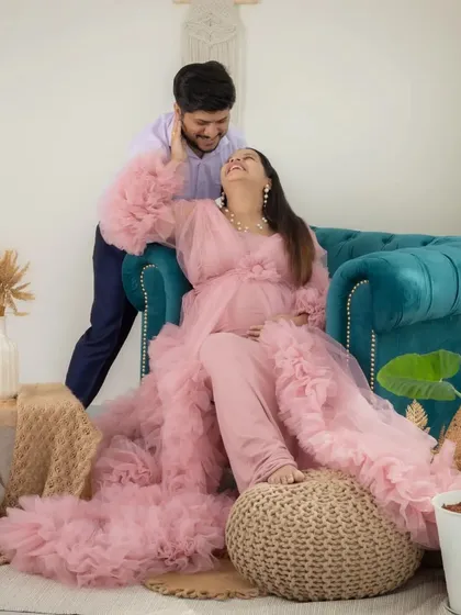 Pure happiness and laughter. This candid moment during a studio maternity session, with the mom-to-be in a stunning pink gown, is just infectious.