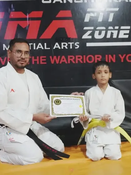 A young student receives his yellow belt, marking a successful belt test and a step forward in his martial arts journey.