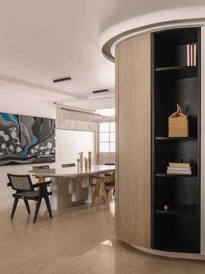 A wide shot of the dining area, showing the curved wall that leads into the space and the dramatic artwork that anchors it.