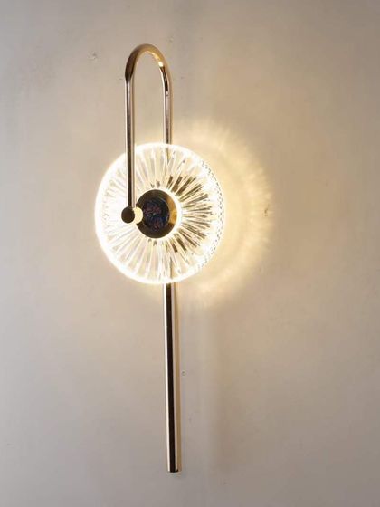 A lollipop-style wall sconce with a textured glass disc. This playful design is perfect for adding a unique touch to a room.