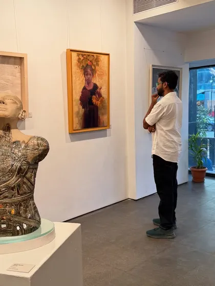 A visitor at the gallery observing my painting "Hope of Innocent Flowers."