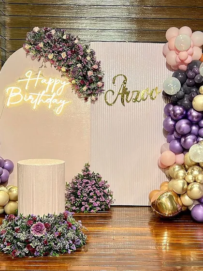 We loved creating this purple and gold themed birthday for Arzoo. The decor features a 'Happy Birthday' neon sign, a custom nameplate, and a beautiful balloon garland in a mix of metallic and matte finishes.