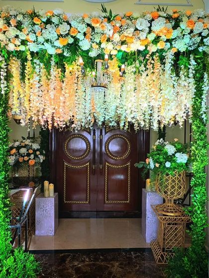 An entrance that feels like a hanging garden. A canopy of cascading white wisteria and a lush floral arch create a dreamy and enchanting passageway for guests.