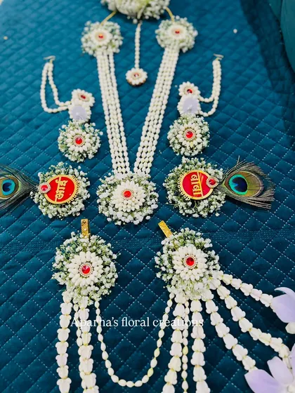 A closer look at the 'Aai' and 'Baba' brooches, which are part of a larger baby shower jewellery set. These are made with fresh flowers and peacock feathers.