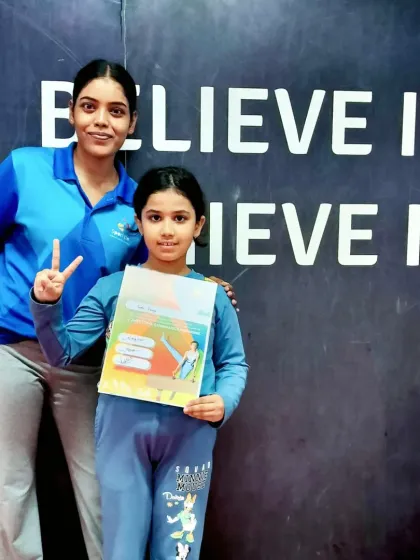 Peace signs and a proud smile. This student and her coach celebrate her latest certification, a testament to her dedication in our gymnastics program.