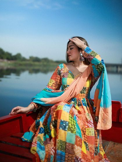 A serene, seated pose of the model on the red boat, creating a peaceful and picturesque moment.