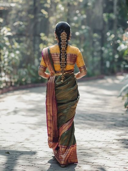 A stunning back view of Akanksha's engagement ensemble, showcasing her traditional braided hairstyle and the elegant simplicity of her blouse.