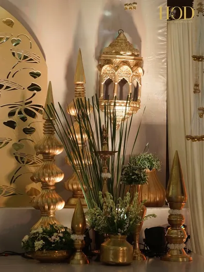 An opulent corner with tall, ornate golden finials, a Moroccan-style lantern, and brass vases, creating a rich and royal atmosphere.