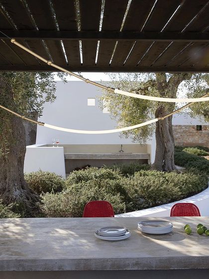 The Leda outdoor lighting system, with its flexible glowing tubes, is shown here illuminating a beautiful patio space.