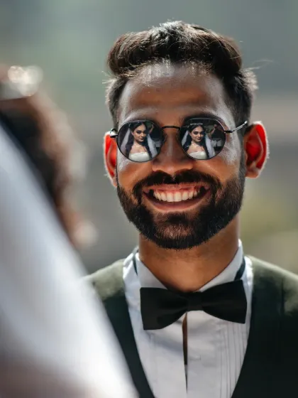I'm always looking for creative ways to tell your story. Here, the bride's reflection in the groom's sunglasses becomes a multi-layered portrait, a small detail that speaks volumes about their connection. It’s these little creative touches that make your photos unique.