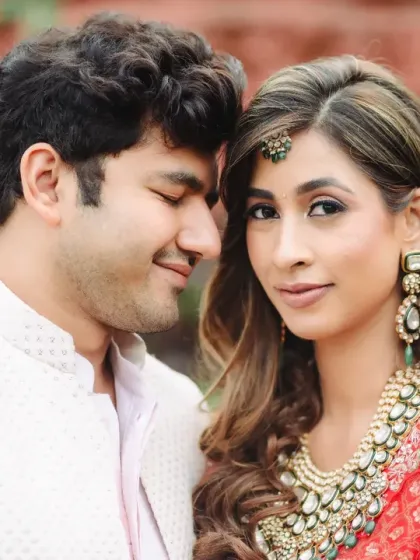 A close, intimate portrait of the couple. The bride's striking beauty in her red attire and the groom's gentle expression create a powerful image of love and connection.