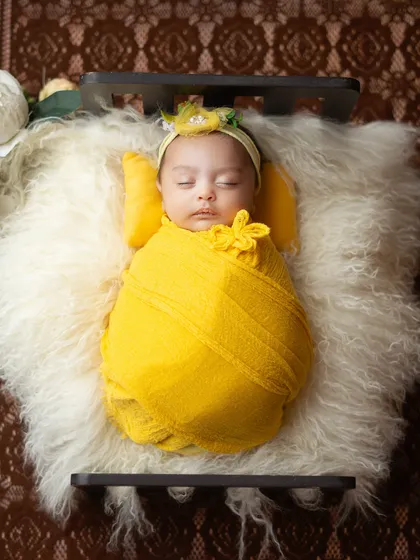 An aerial shot that creates a beautiful, artistic composition, with the baby looking like a precious gift.