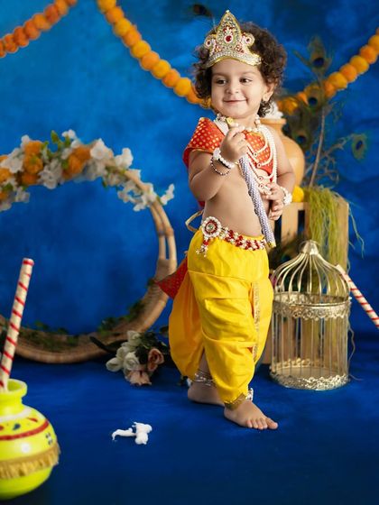 A standing pose for our little Krishna, showing off the full costume and adorable stance.