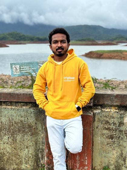 Our trip captain posing by the Banasura Sagar Dam in Wayanad, wearing our signature Tripbae hoodie.
