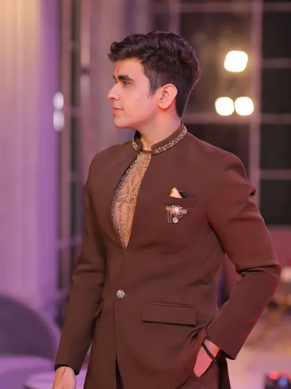 A happy client looking dapper in our brown Jodhpuri suit. The jacket is paired with an embroidered kurta, creating a layered and sophisticated look.