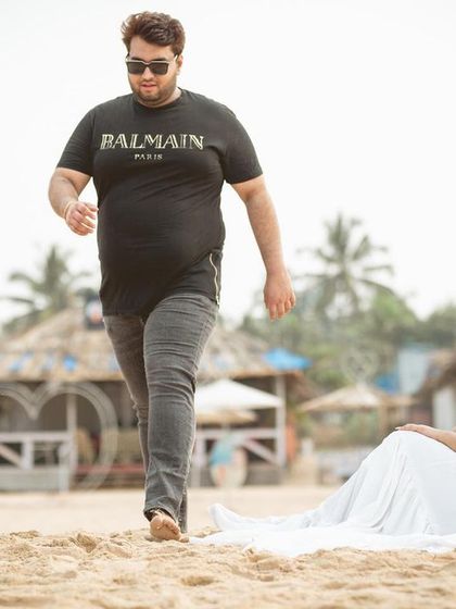 A relaxed and stylish shot from a Goa beach pre-wedding shoot, showcasing the casual and fun side of their relationship.
