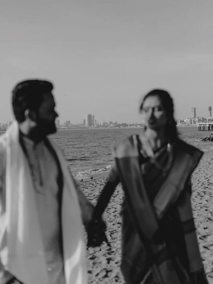 An artistic, blurry black and white shot of a Maharashtrian couple on the beach, creating a dreamy, nostalgic feel.