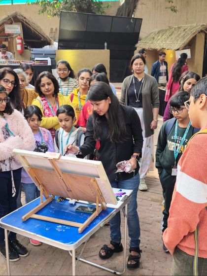 An instructor provides a live demonstration to an engaged group of students, sharing her techniques for capturing the outdoor scenery.