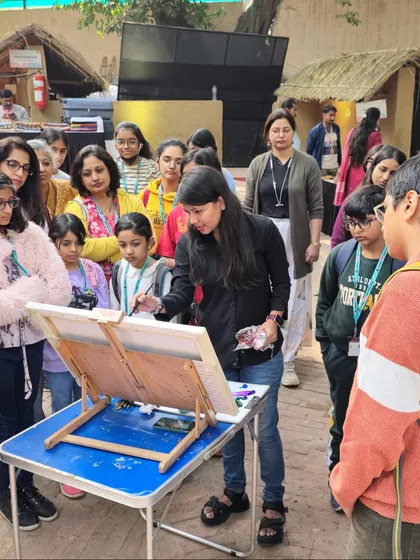 An instructor provides a live demonstration to an engaged group of students, sharing her techniques for capturing the outdoor scenery.