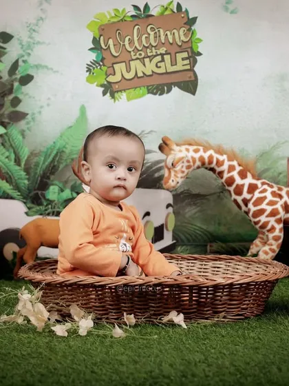 A calm moment amidst the wild. This portrait showcases the detailed jungle backdrop and the variety of animal props we use to bring the theme to life.