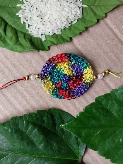 A multicolored spiral rakhi, handcrafted with care. A bright and festive choice for the occasion.