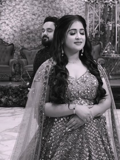 A tender black and white moment between a couple at their reception. The groom embraces the bride from behind, and their serene expressions convey a sense of peace and deep affection.