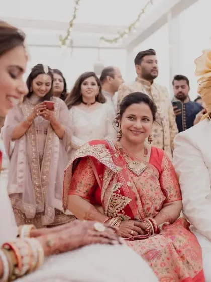 A mother's proud and happy smile as she sits beside her daughter during the wedding ceremony. These are the family moments we cherish.