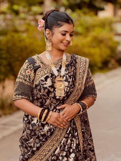 A happy client looking beautiful in a black and gold brocade Nauvari. This is a very elegant and classic choice.