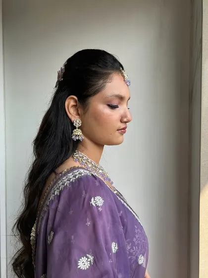 A side profile that highlights the soft waves in the hair and the delicate, blended eyeshadow.