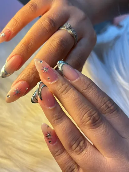 A close-up showing the detail of our 'Coldplay' inspired nails. The combination of sculpted chrome, tiny stars, and sparkling rhinestones creates a truly magical look.