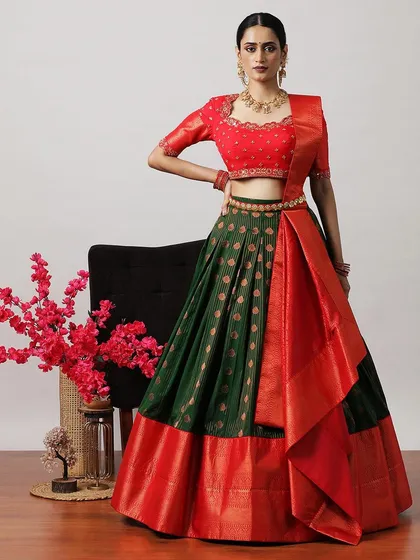 A beautiful green and red half-saree lehenga, featuring a brocade skirt and a rich red Banarasi border and dupatta.