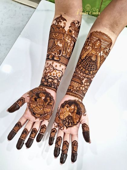 A beautiful bridal mehendi featuring portraits of the couple in medallions on the palms, with a baraat scene and other traditional motifs on the arms.