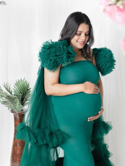 A side profile is perfect for beautifully highlighting the shape of your baby bump. This mom-to-be is glowing in our emerald green gown, a popular choice from my client wardrobe for its rich color.
