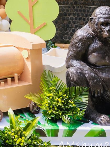 A large gorilla prop sits beside a wooden train, adding a powerful and impressive element to Shourya's safari party.