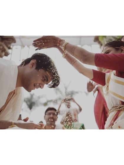 Another angle of the Akshatai ritual, capturing the groom's smile and the gentle blessing.