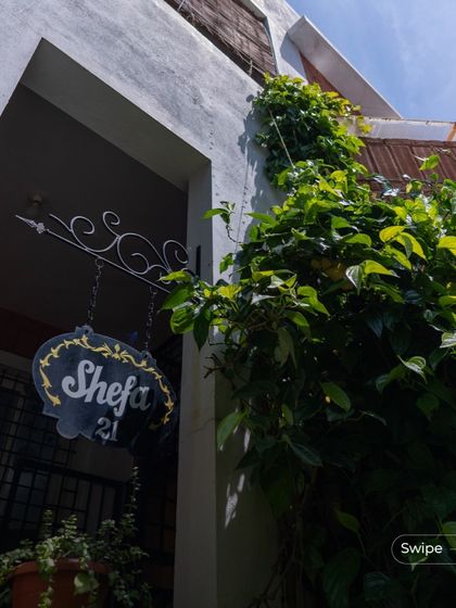A close-up of the entrance to the Gifty Residence, where a climbing vine softens the modern lines and adds a touch of green to the facade.