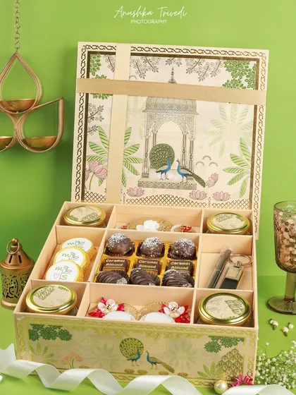 A large, beautifully illustrated hamper box filled with a variety of sweets and savouries. This shot showcases the sheer abundance and variety offered in the gift set.