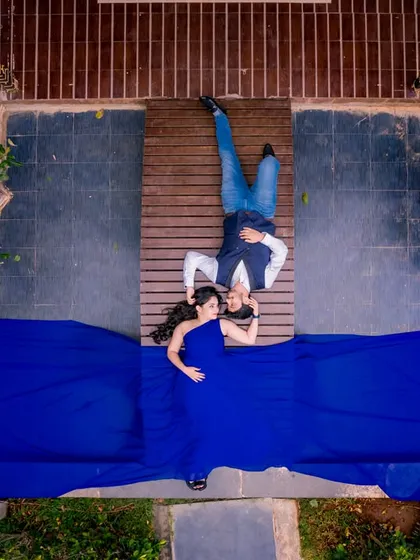 A drone's-eye view shows the grand scale you can achieve here. The flowing dress against the wooden deck and greenery creates a stunning, high-impact visual for your pre-wedding album.