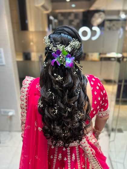 A close-up of the floral arrangement in the curly hairstyle.