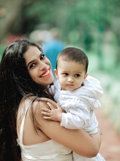 A candid portrait of a mother and her baby boy, sharing a sweet moment during their outdoor photoshoot. The natural setting allows for relaxed and authentic expressions.